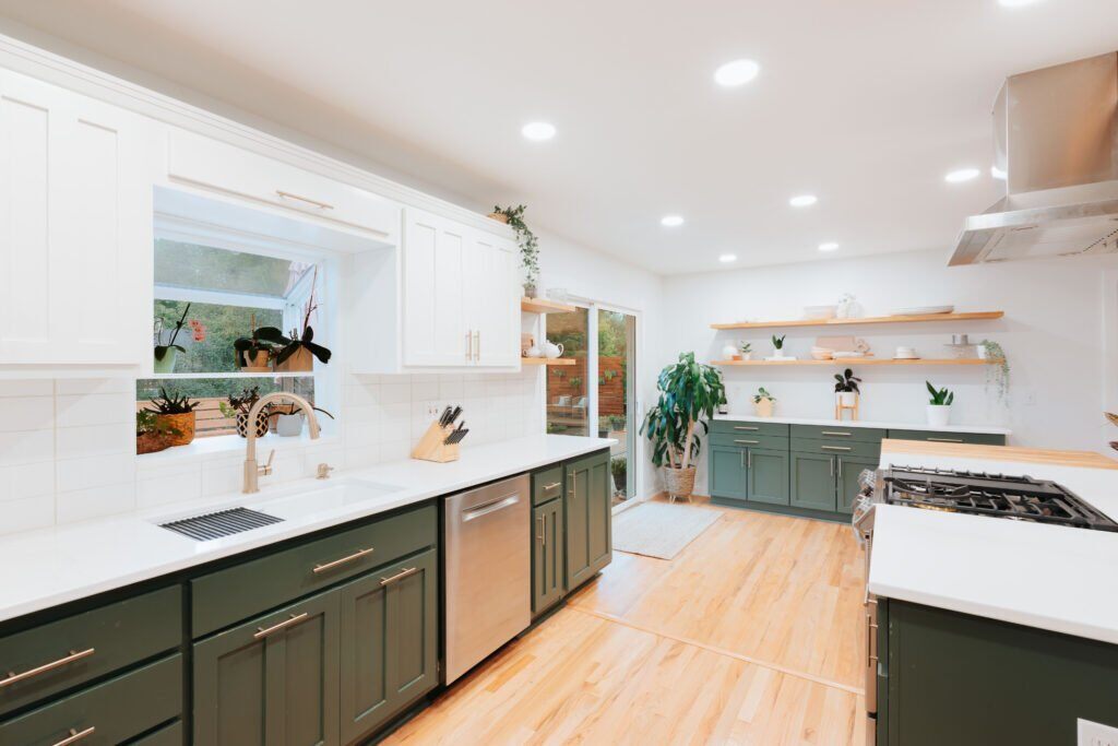 A beautiful kitchen with green and white cabinets.