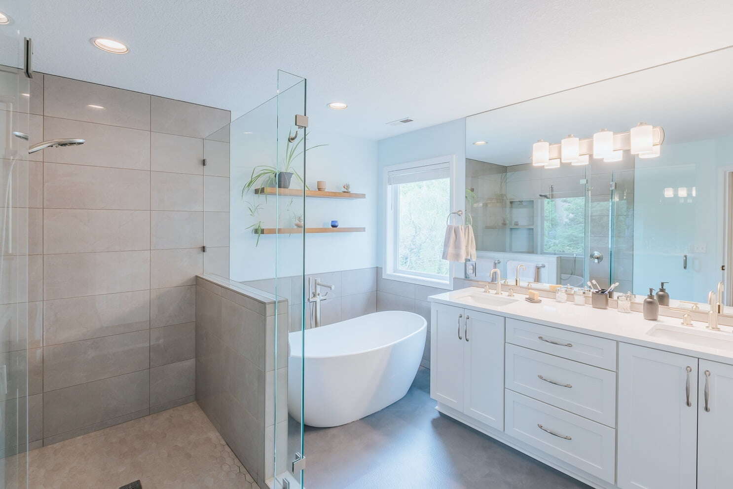bathroom after a remodel with freestanding acrylic tub and custom tile shower