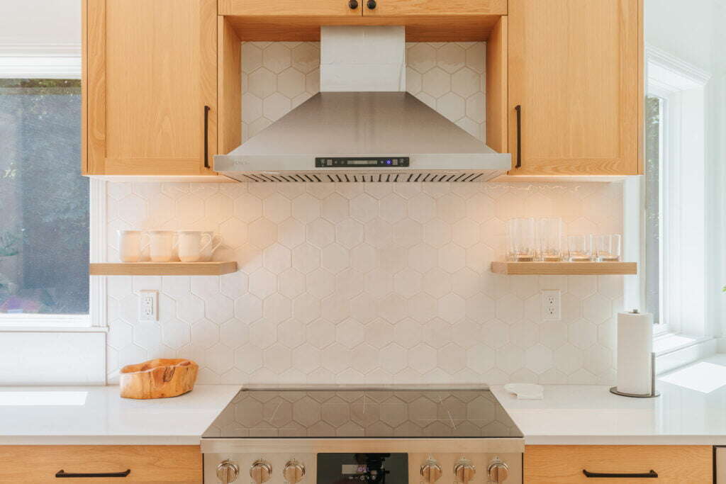 remodeled kitchen featuring stainless steel oven range and hood