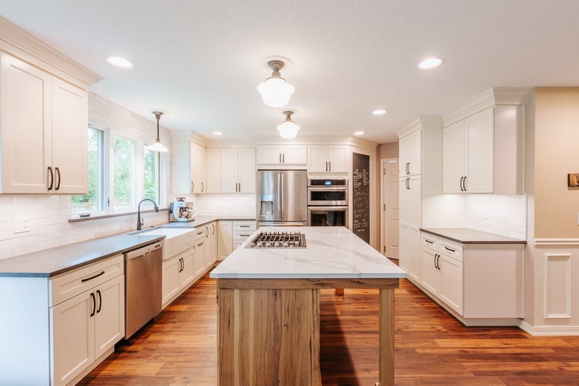 Mixed material kitchen island with white kitchen cabinets