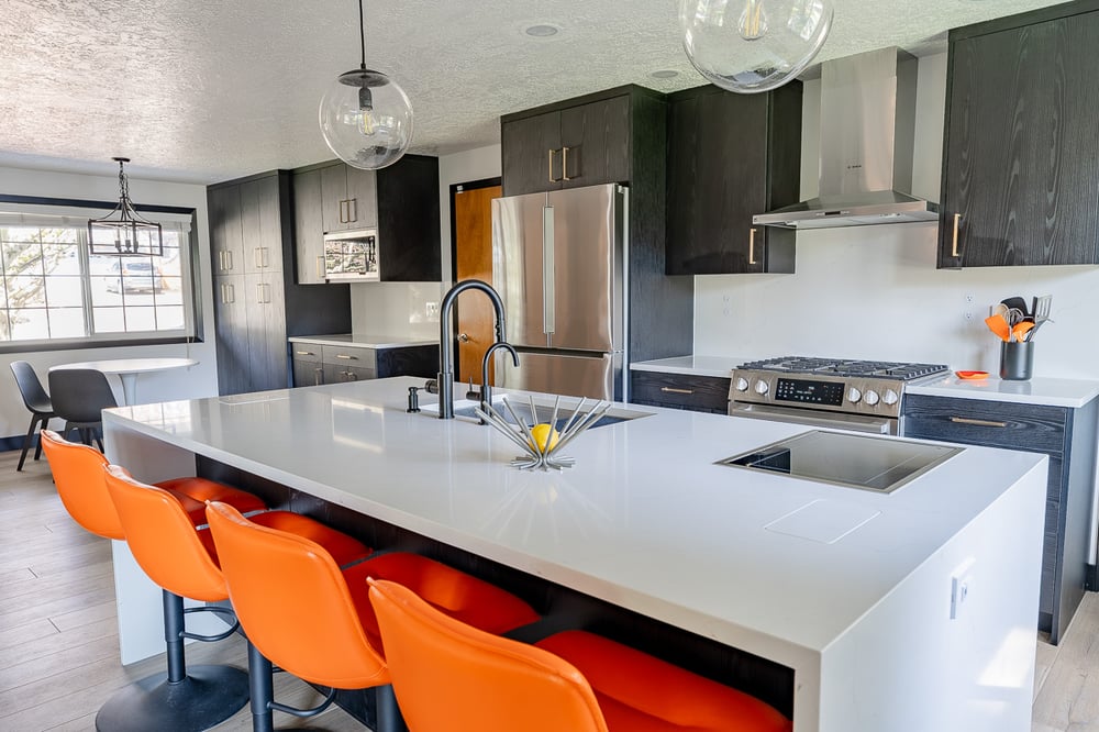 White island, black cabinets, and orange chairs