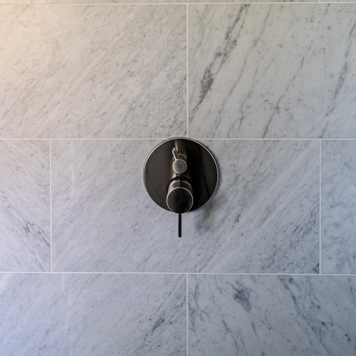 Close up detail of tile and shower handle