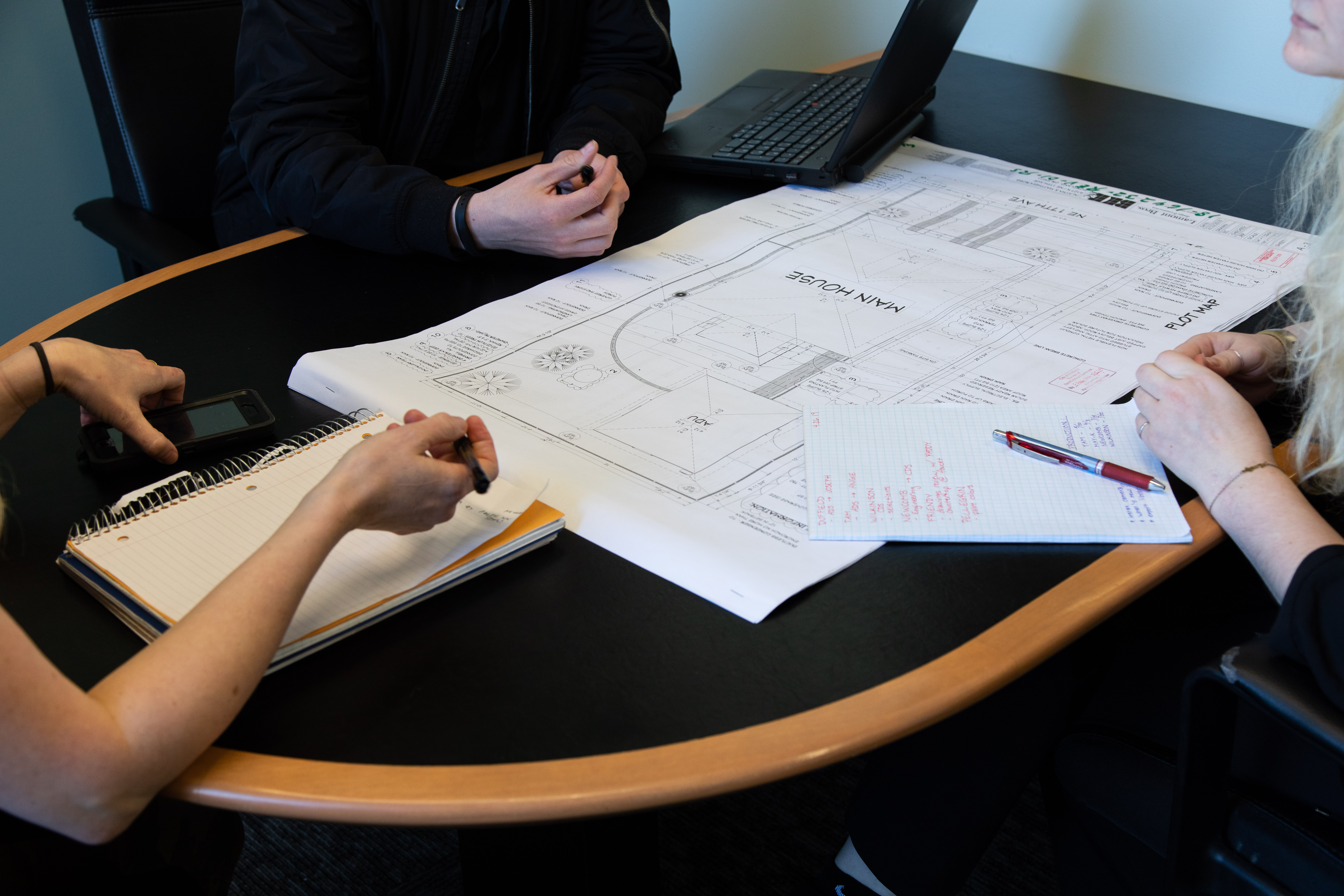 top 5 remodeling mistakes to avoid: people around table looking over remodel plans